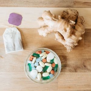 bowl of pills and ginger root on a table